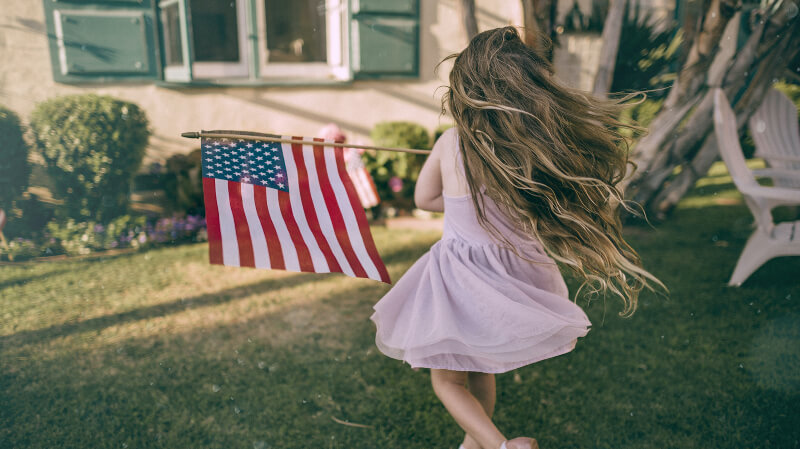 アメリカ国旗をもって走る女の子